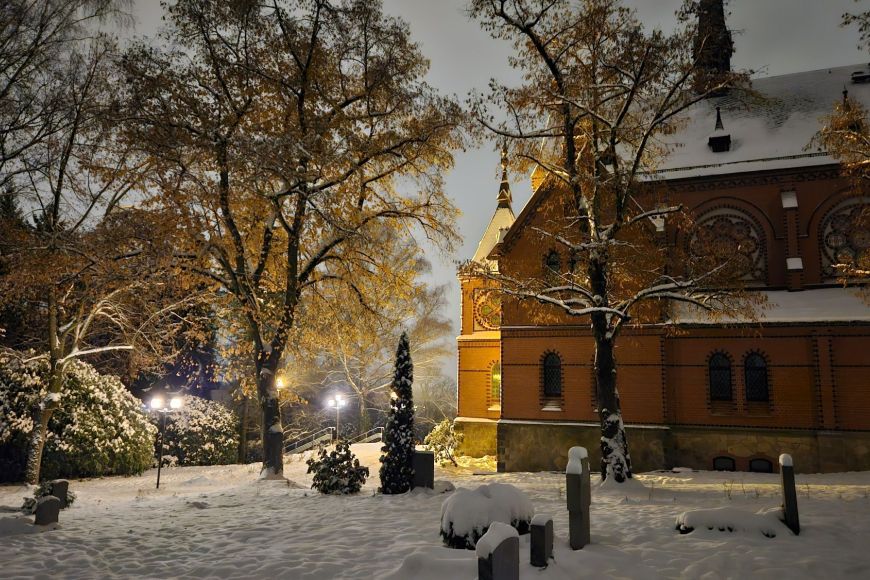 Friedhof im Winter – Grabsteine mit dicken Schneemützen im Abendlicht