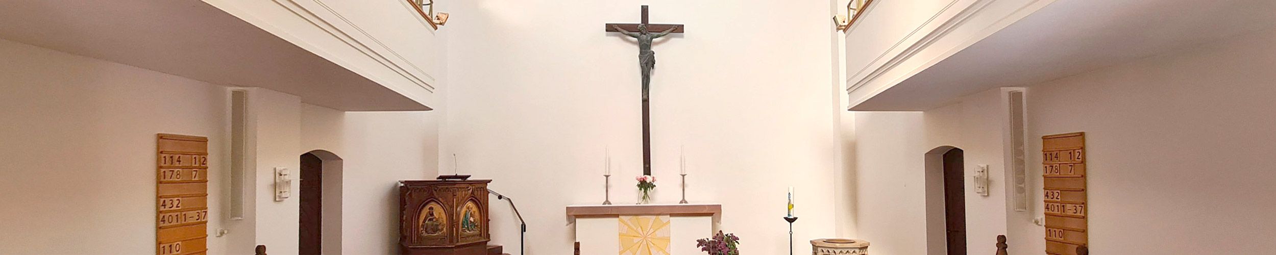 Kirchenraum mit Kanzel, Altar, Kruzifix und Emporen