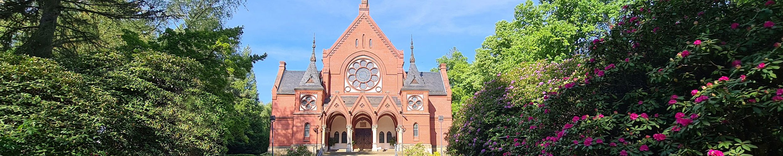 frontale Ansicht der Kirche, rechts und links umgeben von Bäumen